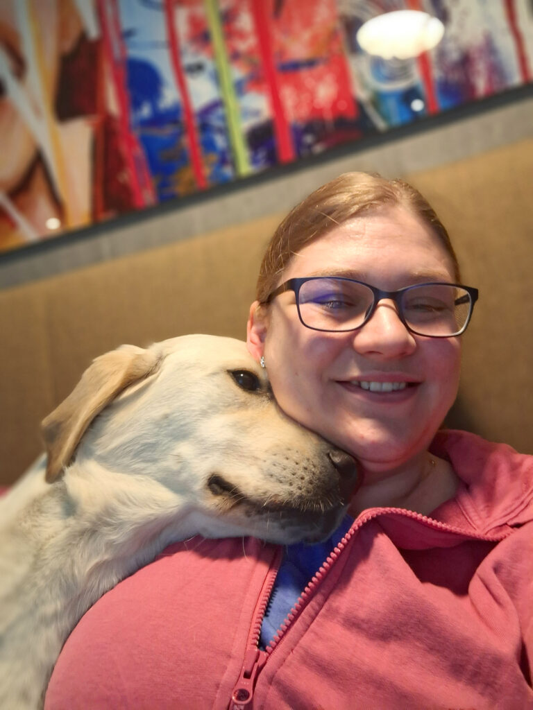 Assistenzhündin Lilly mit Klara am Kuscheln