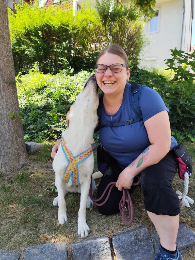 Assistenzhündin Lilly mit Klara am Kuscheln