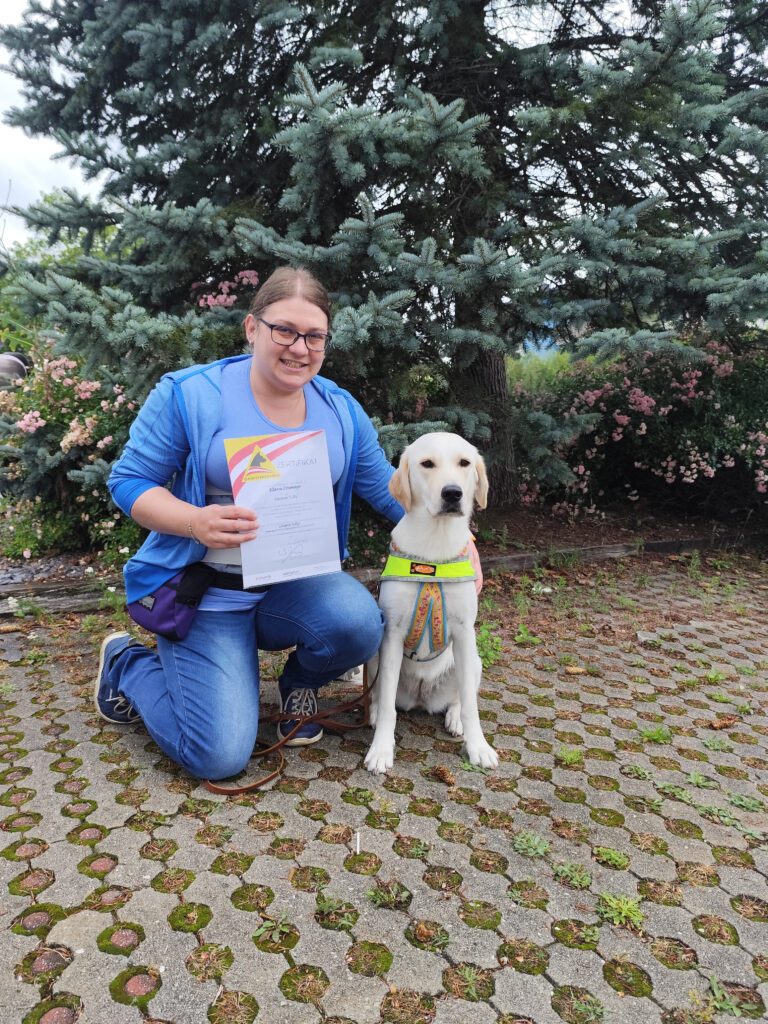 Klara mit Assistenzhündin Lilly und Zertifikat